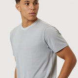 Man wearing a light gray t-shirt against a plain background