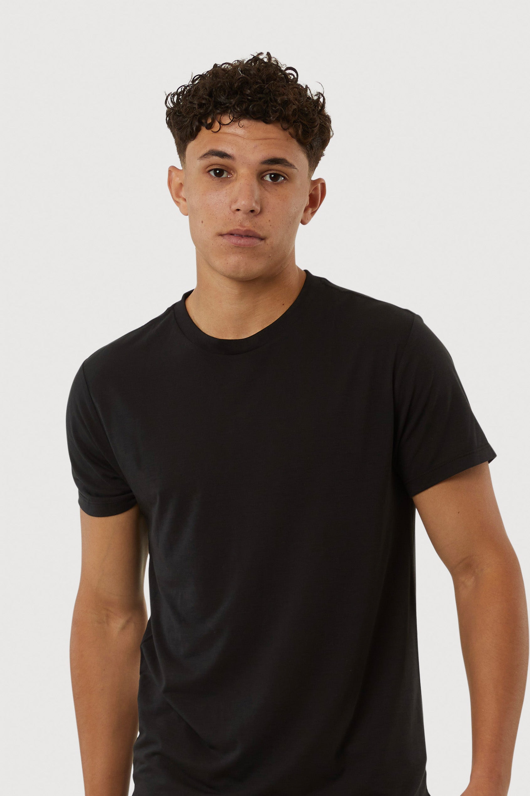 Person wearing a black t-shirt against a white background