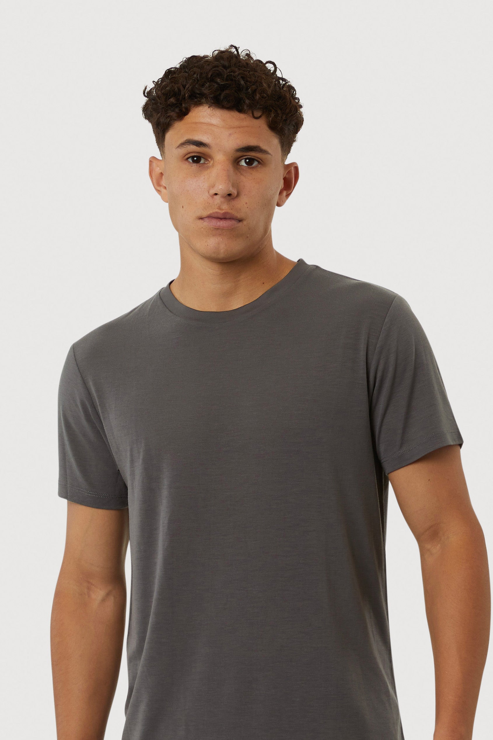 Man wearing a gray t-shirt against a white background