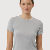 Woman wearing a light gray t-shirt and pants on a white background