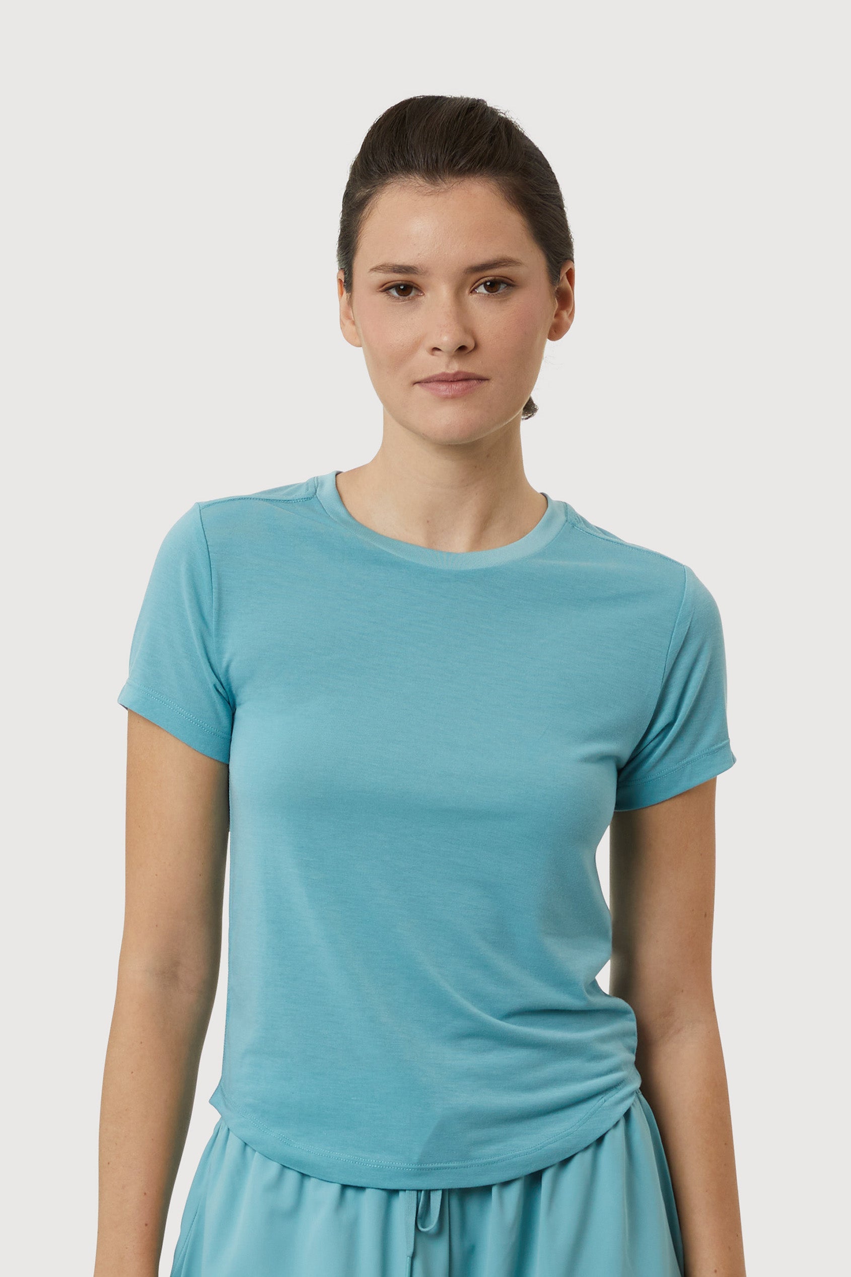 Woman wearing a blue t-shirt against a light gray background
