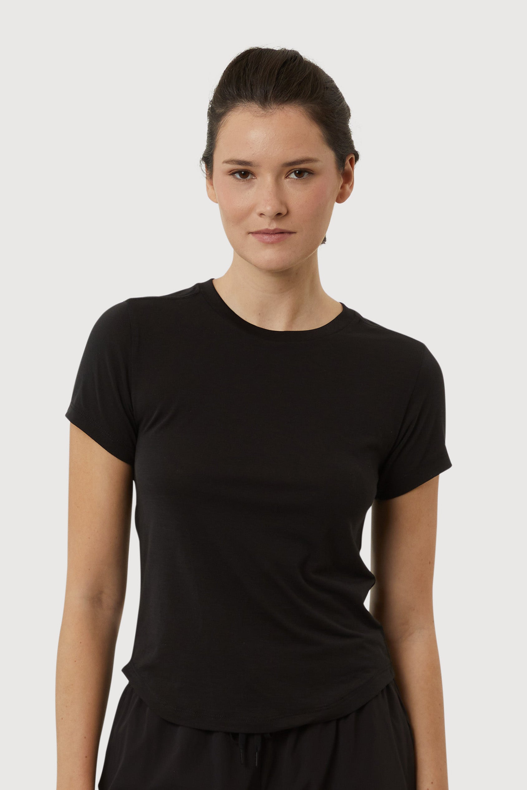 Woman wearing a black t-shirt against a plain background