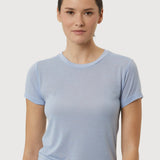 Woman wearing a light blue t-shirt against a plain background