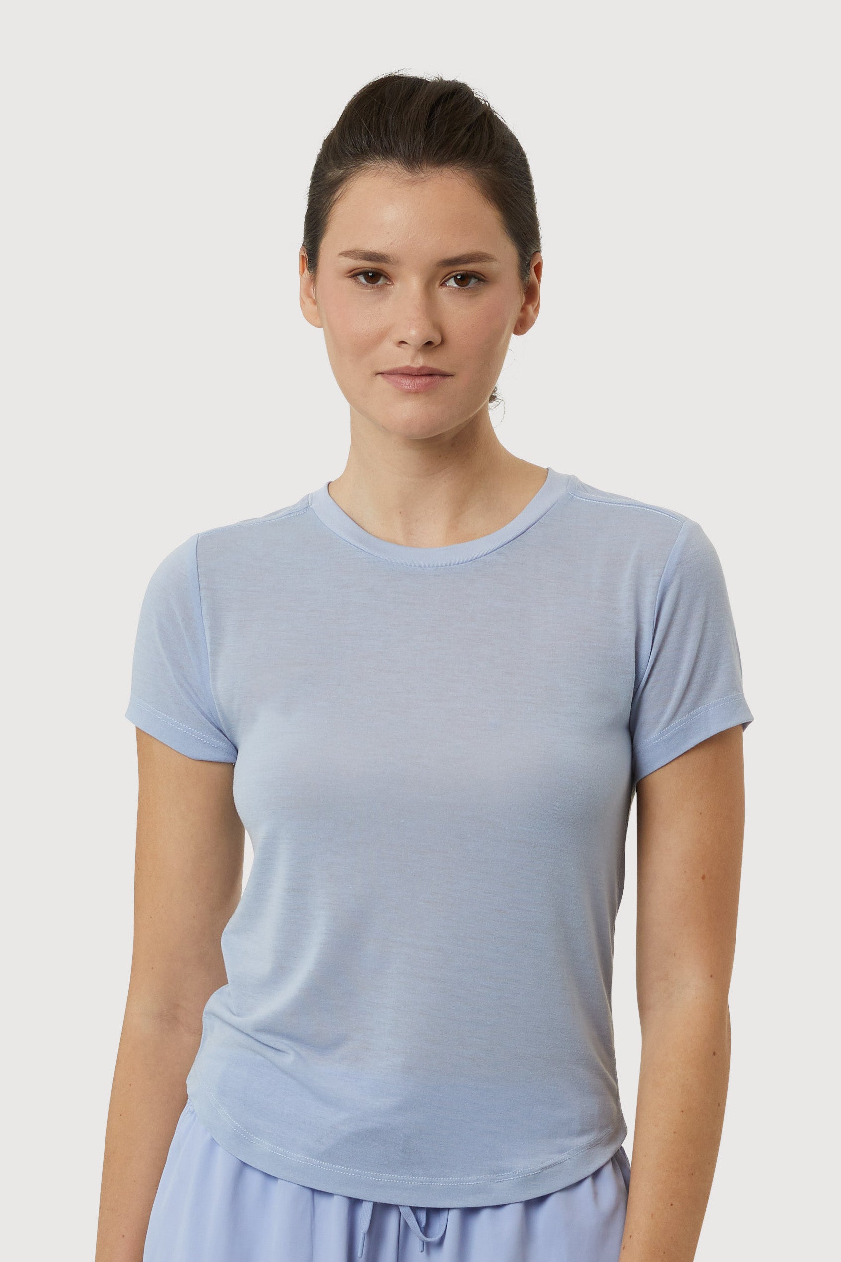 Woman wearing a light blue t-shirt against a plain background