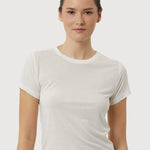Woman wearing a plain white t-shirt against a light gray background