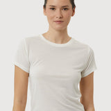 Woman wearing a plain white t-shirt against a light gray background