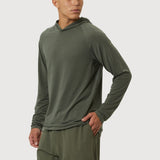 Man wearing a green hoodie and shorts on a white background