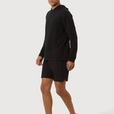 Person wearing a black long-sleeve shirt and shorts on a white background