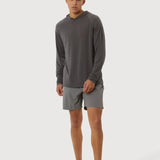 Man wearing a gray long-sleeve shirt and shorts on a white background