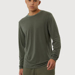 Man wearing a green long-sleeve shirt and shorts on a white background