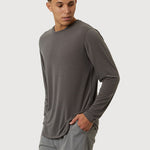 Man wearing a gray long-sleeve shirt and shorts on a white background