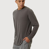 Man wearing a gray long-sleeve shirt and shorts on a white background