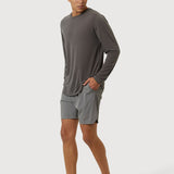 Man wearing a gray long-sleeve shirt and shorts on a white background