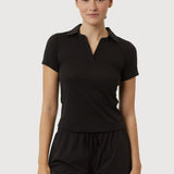 Woman wearing a black polo shirt and shorts on a white background