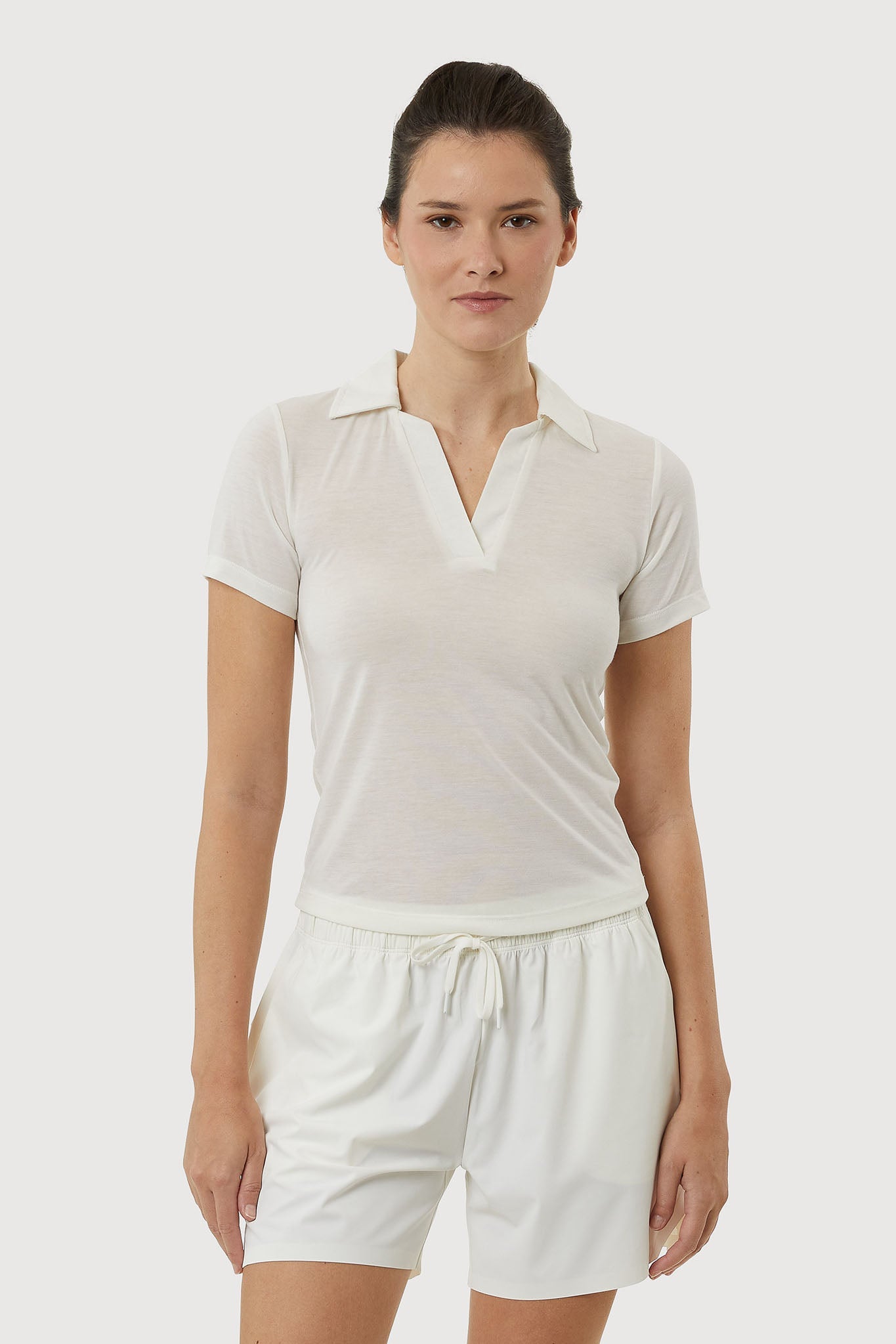 Woman wearing a white outfit on a plain background