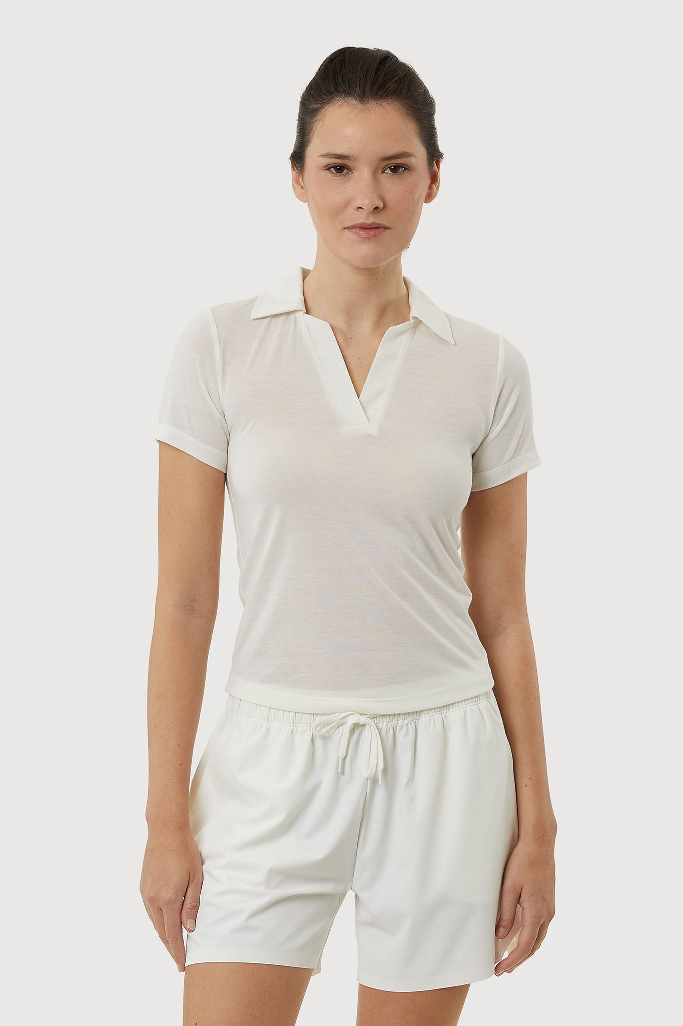 Woman wearing a white outfit on a plain background