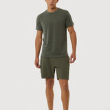 Man wearing a green t-shirt and shorts on a white background