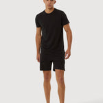 Person wearing a black t-shirt and shorts on a white background