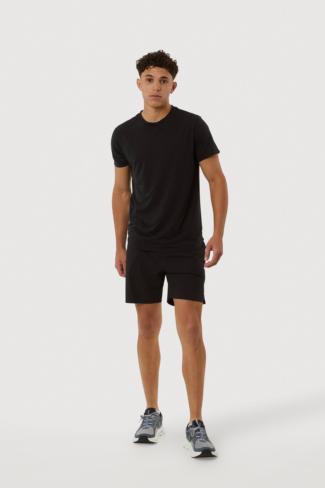 Person wearing a black t-shirt and shorts on a white background