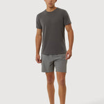 Man wearing a gray t-shirt and shorts on a white background