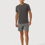 Man wearing a gray t-shirt and shorts on a white background