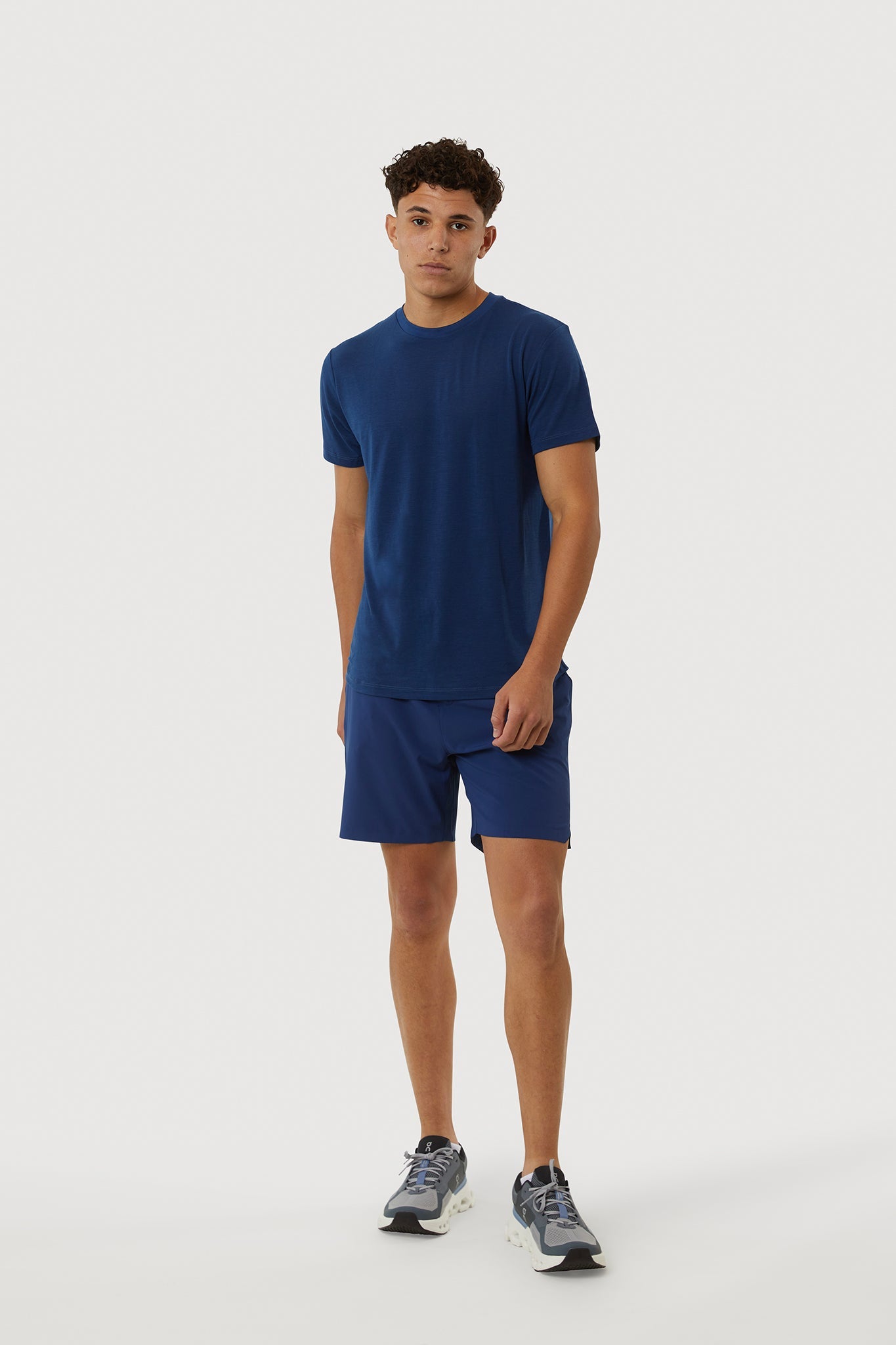 Person wearing a blue t-shirt and shorts set on a white background