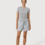 Woman wearing a gray t-shirt and shorts on a white background