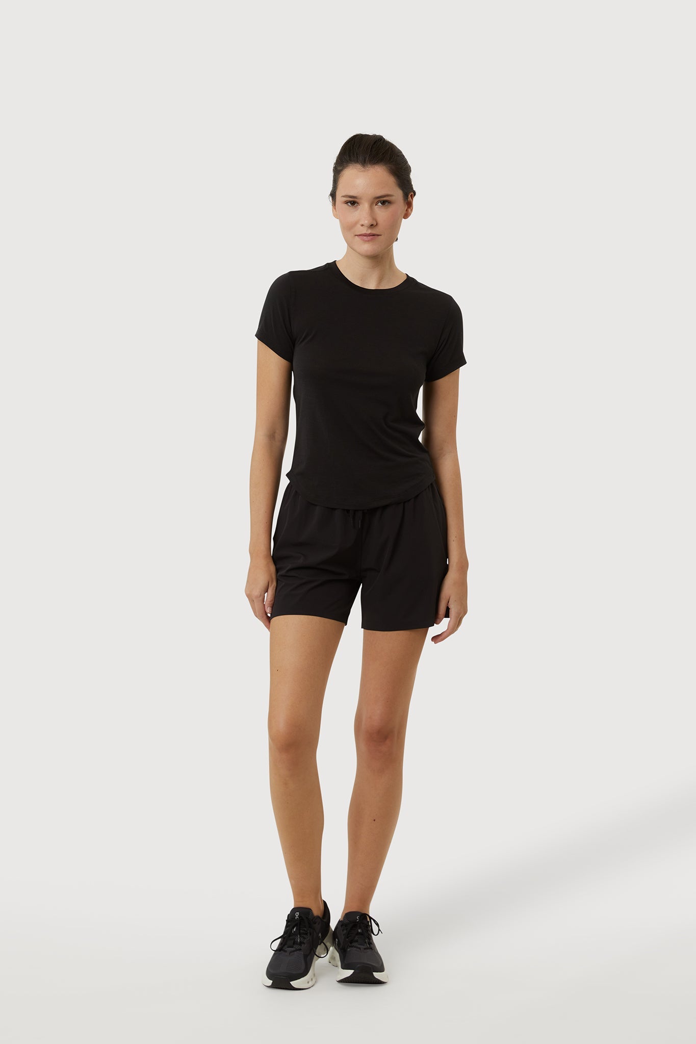 Person wearing a black t-shirt and shorts set on a white background