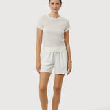 Woman wearing a white t-shirt and shorts set on a white background