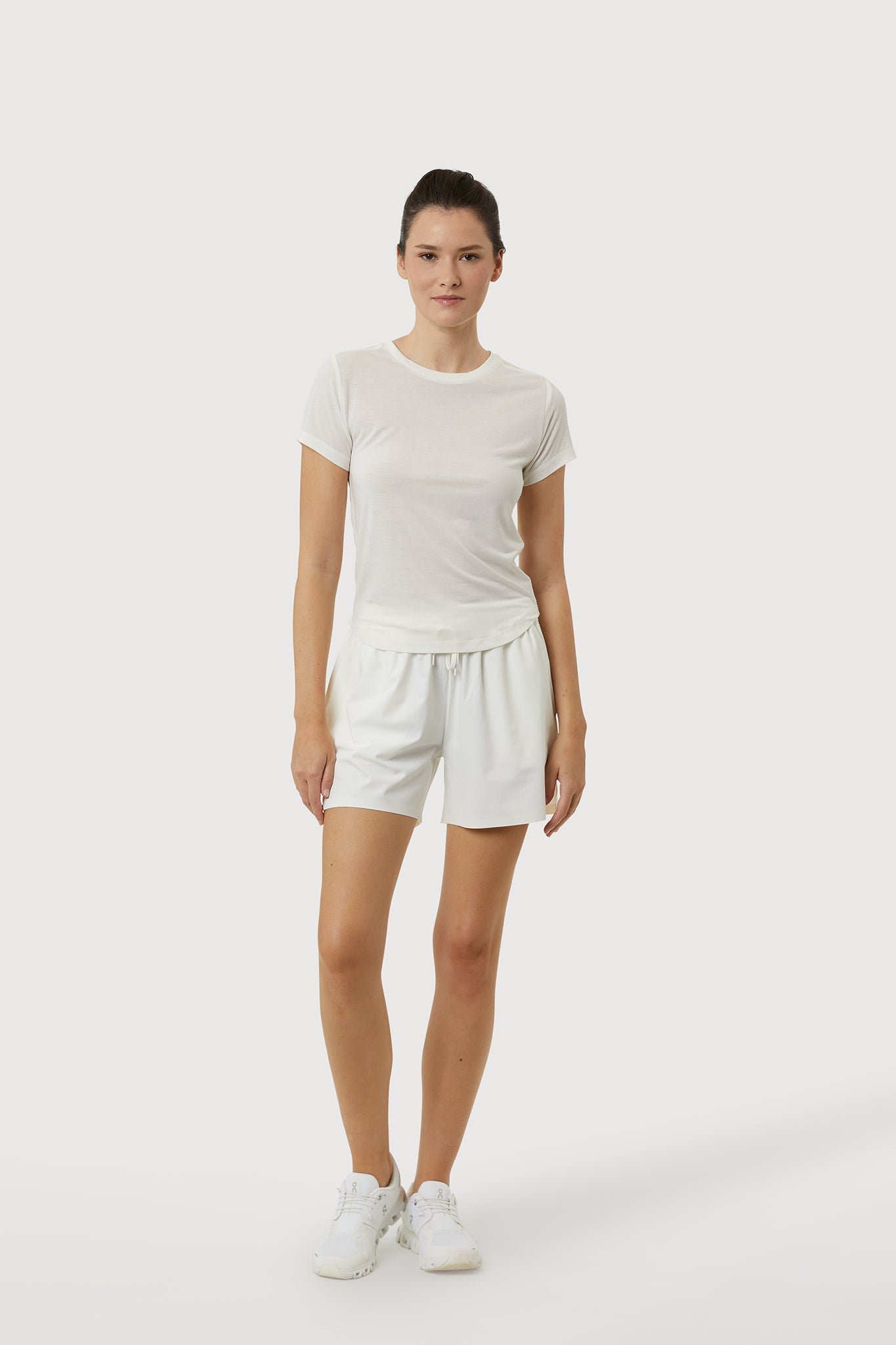 Woman wearing a white t-shirt and shorts set on a white background