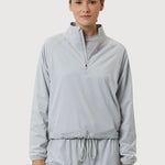 Woman wearing a light gray tracksuit on a white background