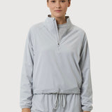 Woman wearing a light gray tracksuit on a white background