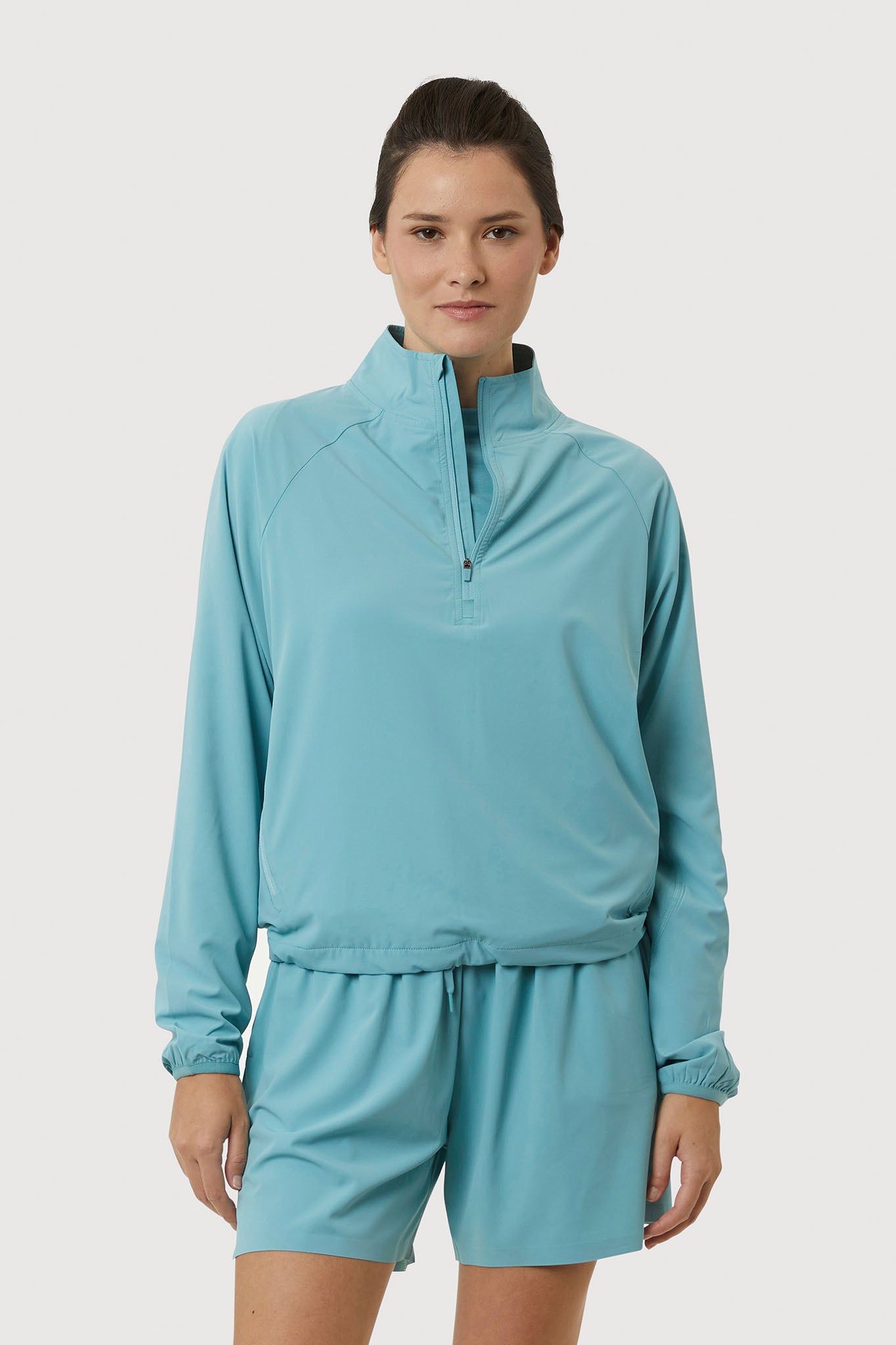 Woman wearing a light blue tracksuit on a white background