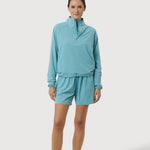 Woman wearing a light blue tracksuit on a white background