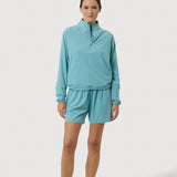 Woman wearing a light blue tracksuit on a white background