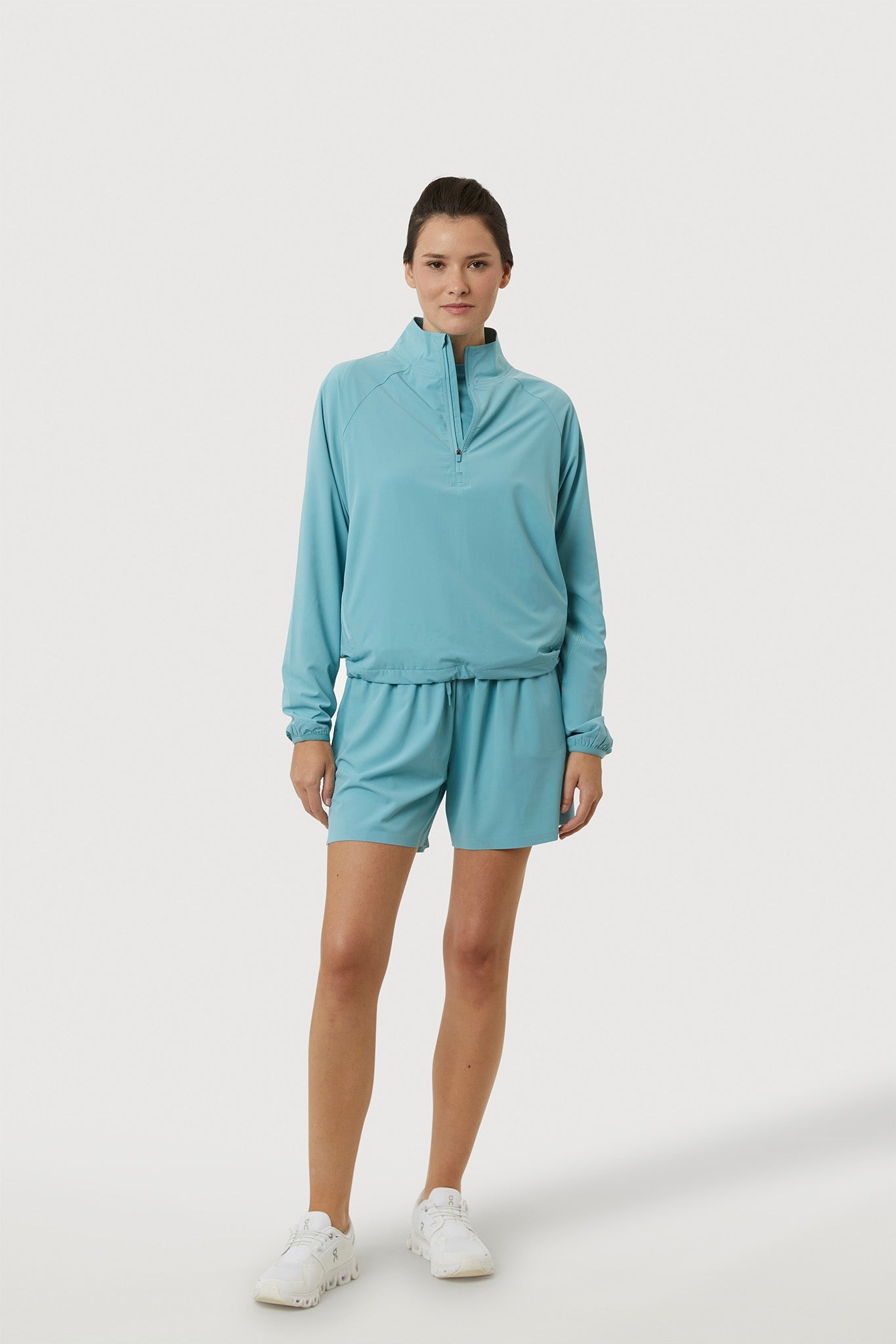 Woman wearing a light blue tracksuit on a white background