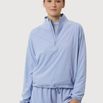 Person wearing a light blue tracksuit on a white background