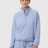 Person wearing a light blue tracksuit on a white background
