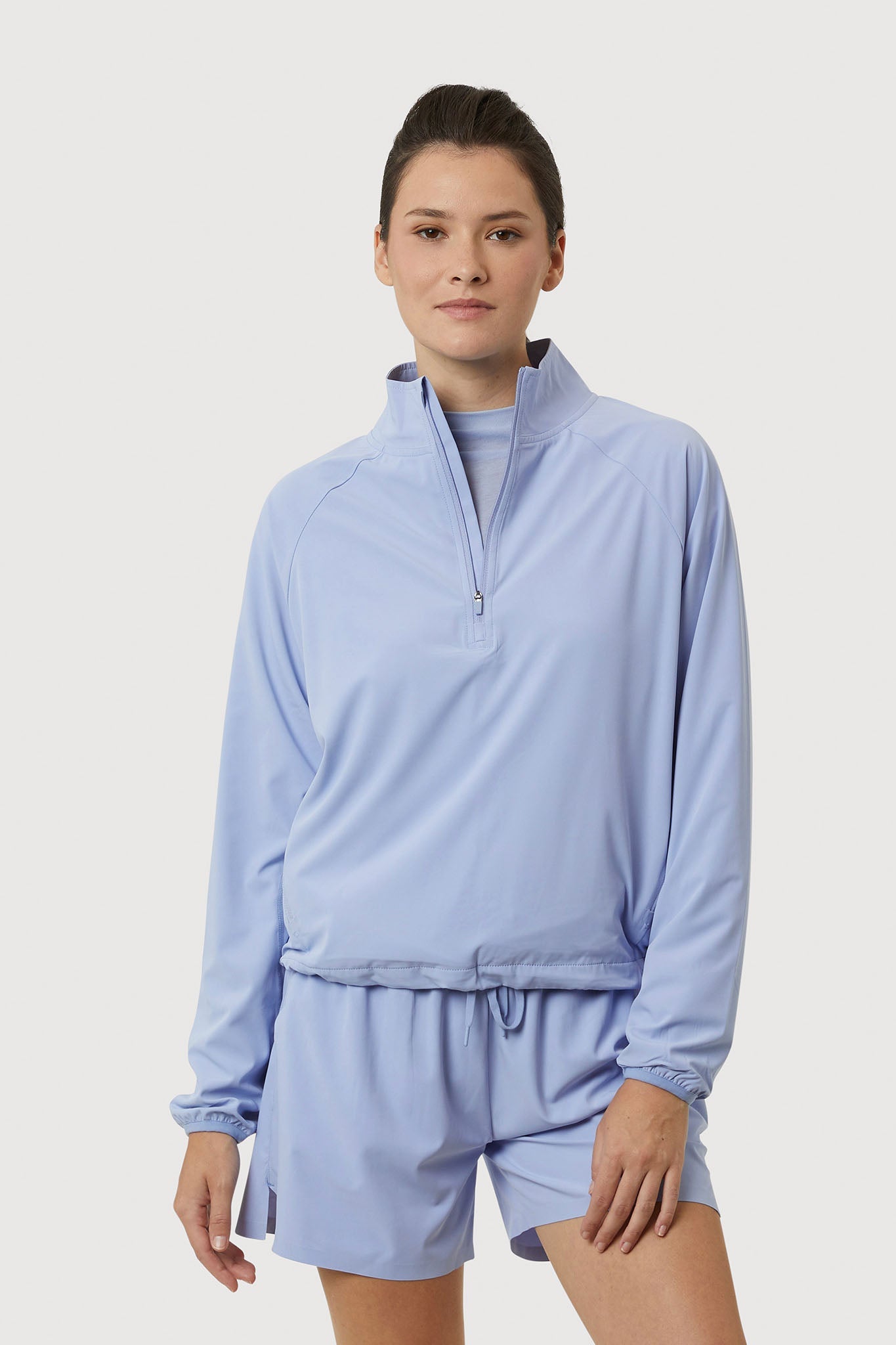 Person wearing a light blue tracksuit on a white background