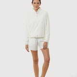 Person wearing a white outfit with shorts on a white background