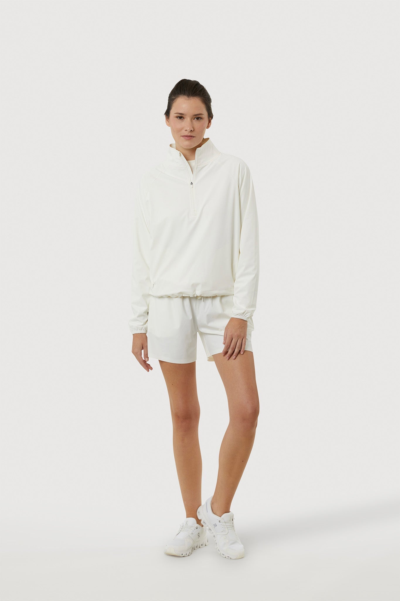 Person wearing a white outfit with shorts on a white background
