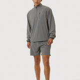 Person wearing a gray long-sleeve shirt and shorts on a white background