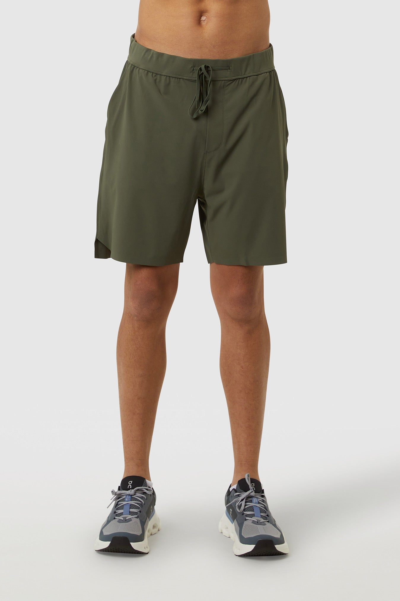 Person wearing olive green shorts on a white background