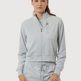 Woman wearing a light gray tracksuit on a white background