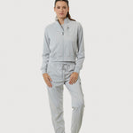 Person wearing a light gray tracksuit on a white background