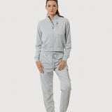 Person wearing a light gray tracksuit on a white background