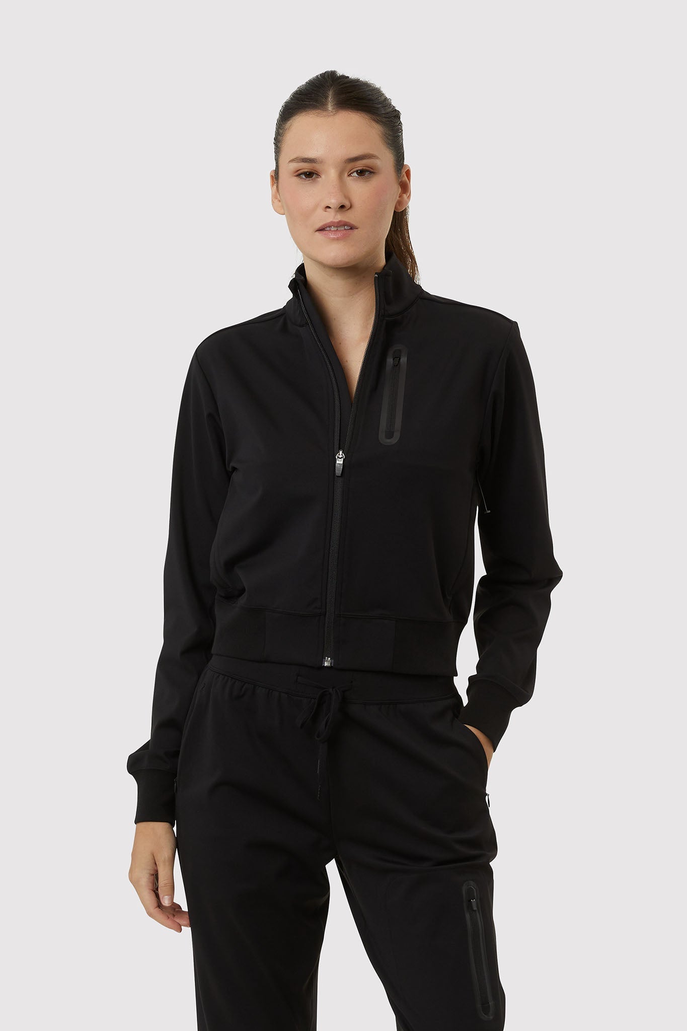 Person wearing a black tracksuit on a white background