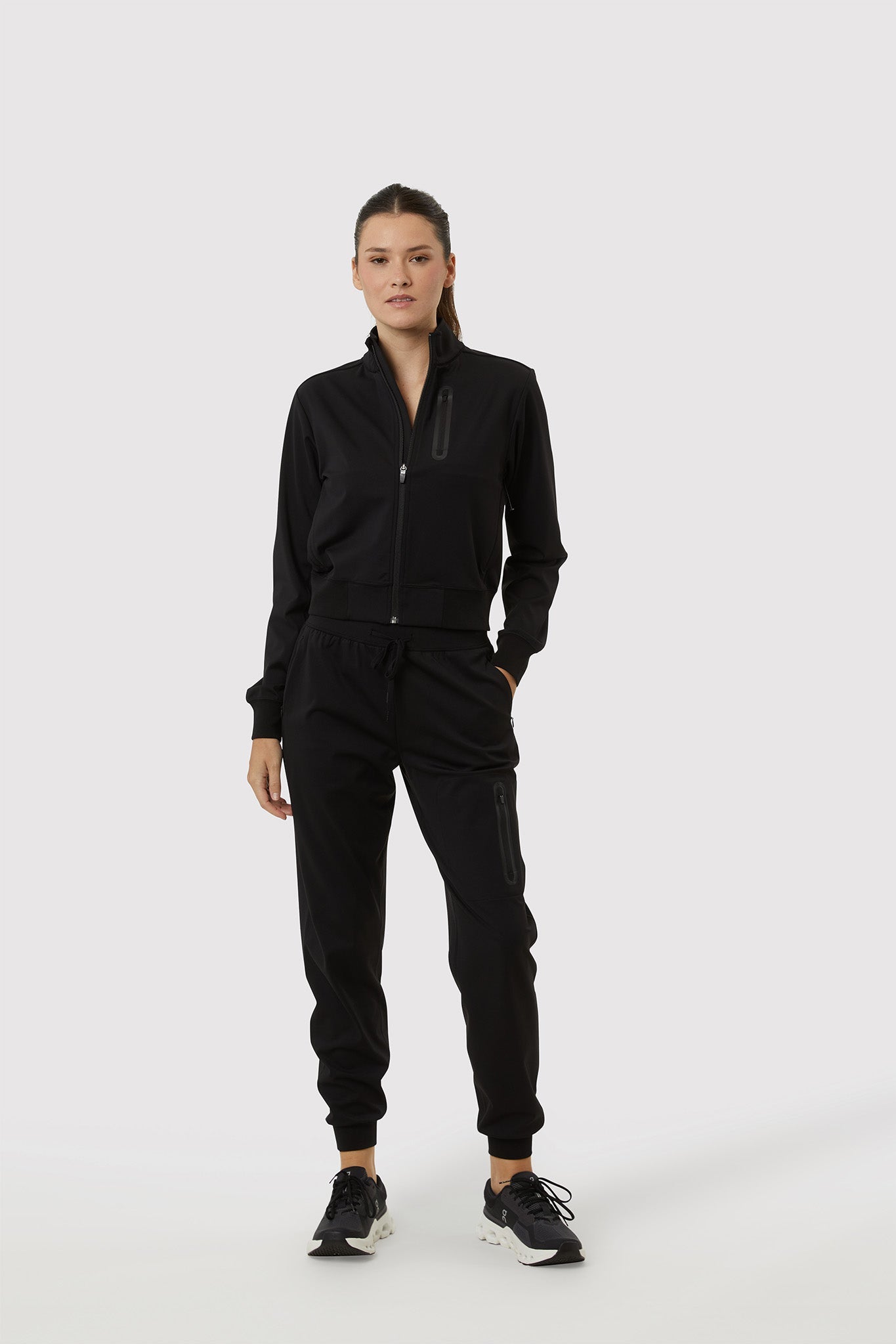 Person wearing a black tracksuit on a white background