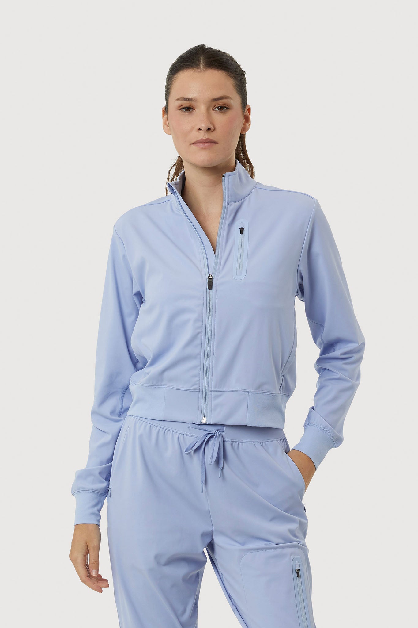 Woman wearing a light blue tracksuit on a white background