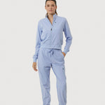 Woman wearing a light blue tracksuit on a white background